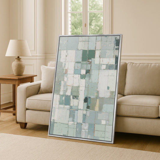 Large geometric abstract art leaning against couch in soft neutral interior