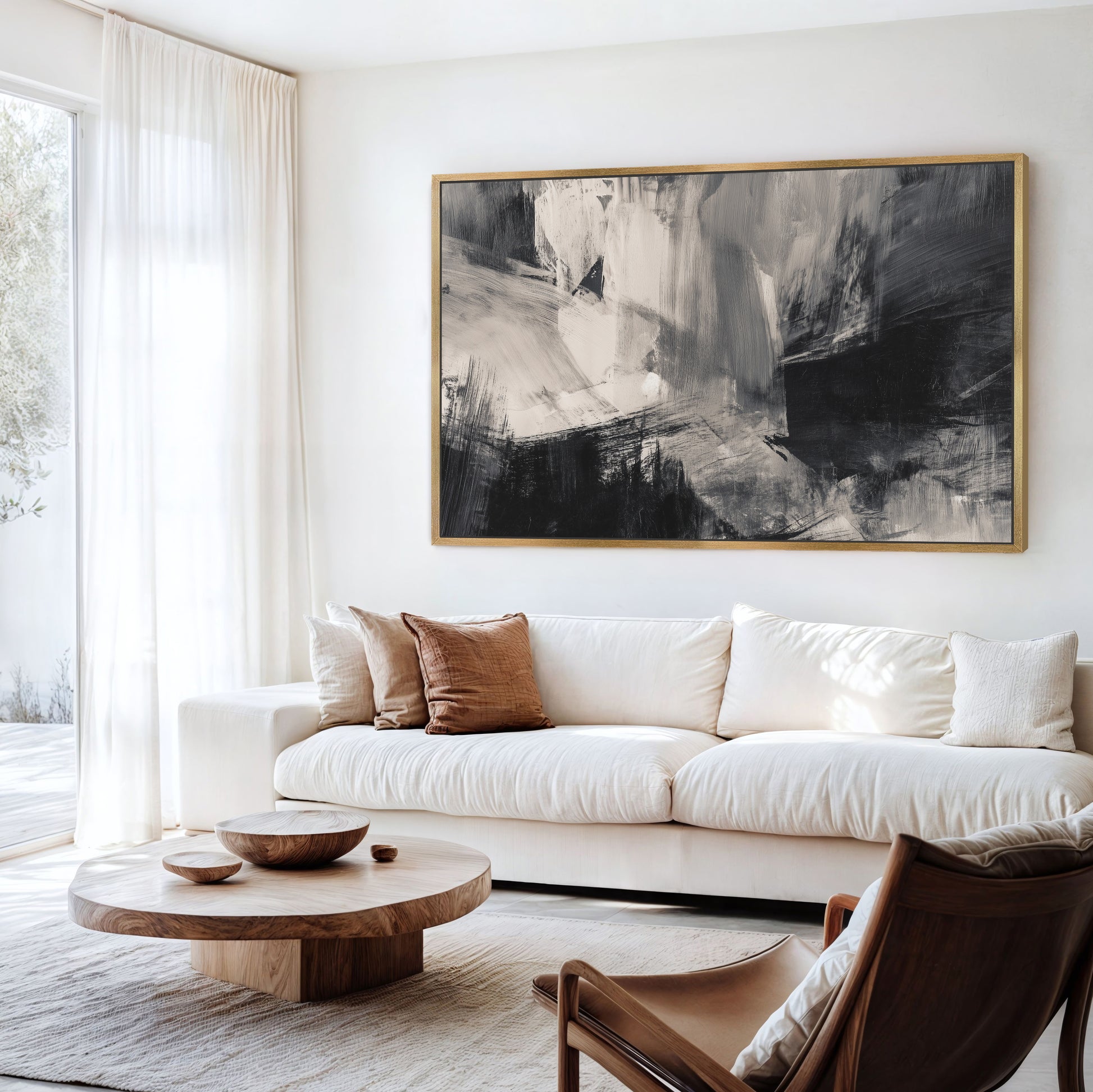 a modern living room with a large abstract painting on the wall, a white sofa, a wooden coffee table, and a brown leather armchair.