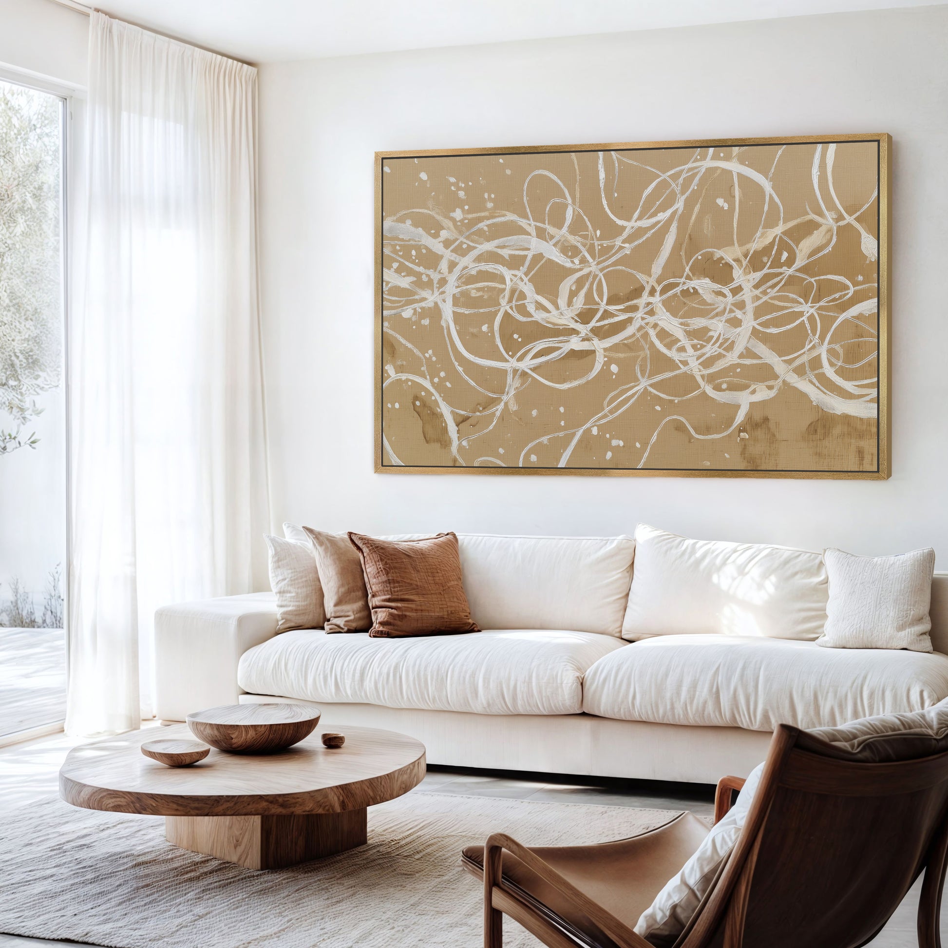 Neutral abstract linework artwork with gold frame in bright modern living room