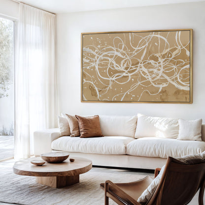 Neutral abstract linework artwork with gold frame in bright modern living room