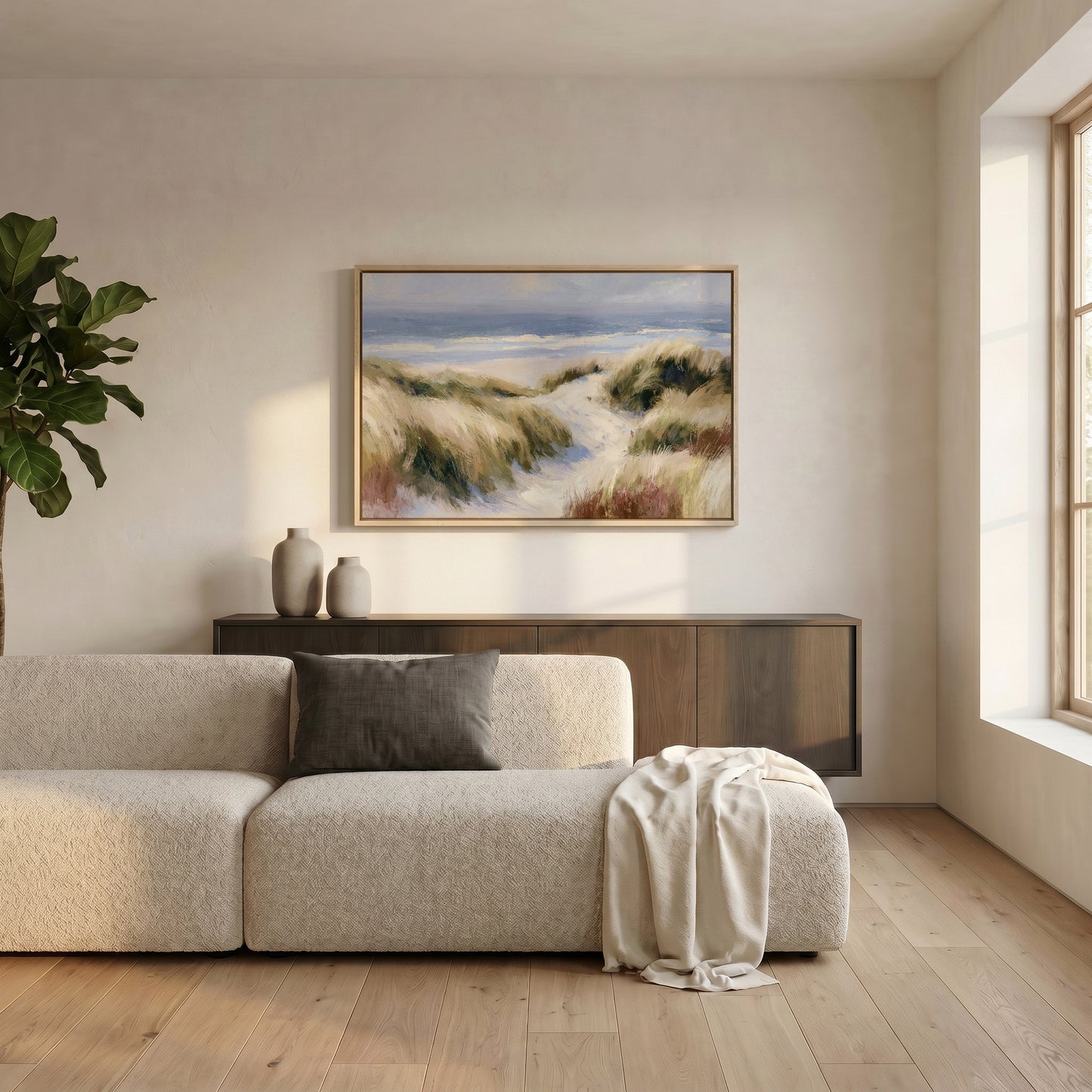 a serene living room with a large window, a beige sofa, a wooden cabinet, and a framed landscape painting hanging on the wall.