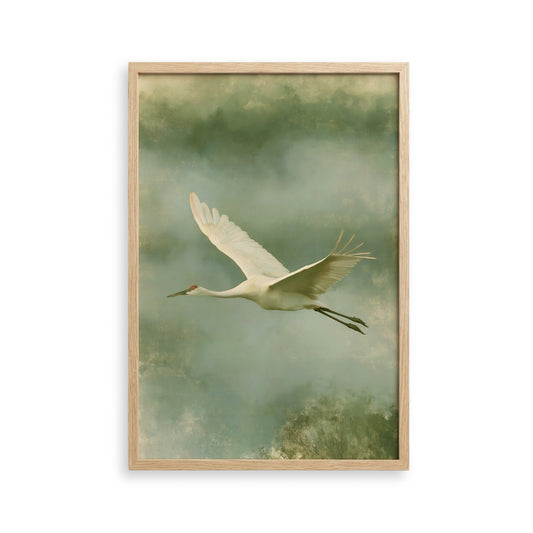 A white crane with outstretched wings is captured in flight against a backdrop of green and gray hues.