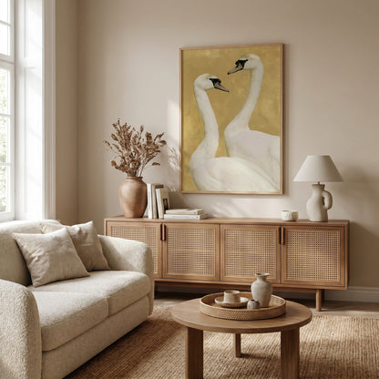 a cozy living room with a large framed painting of two swans on the wall, a beige sofa, a wooden sideboard, and a round coffee table.