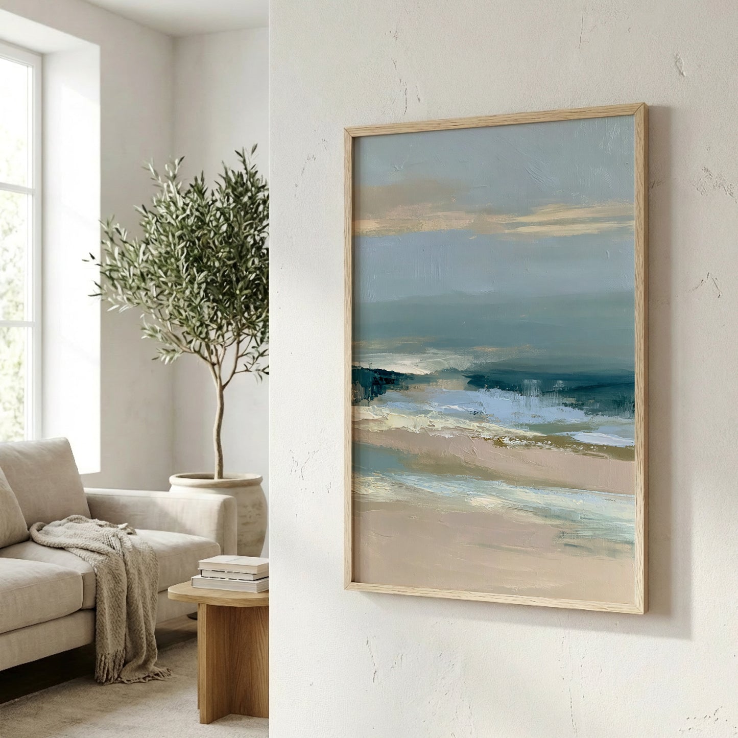 a living room with a large painting of a beach scene hanging on the wall. The painting depicts a serene beach landscape with a clear blue sky and a calm ocean. The room is decorated with a comfortable couch, a wooden coffee table, and a potted plant, creating a cozy and inviting atmosphere.
