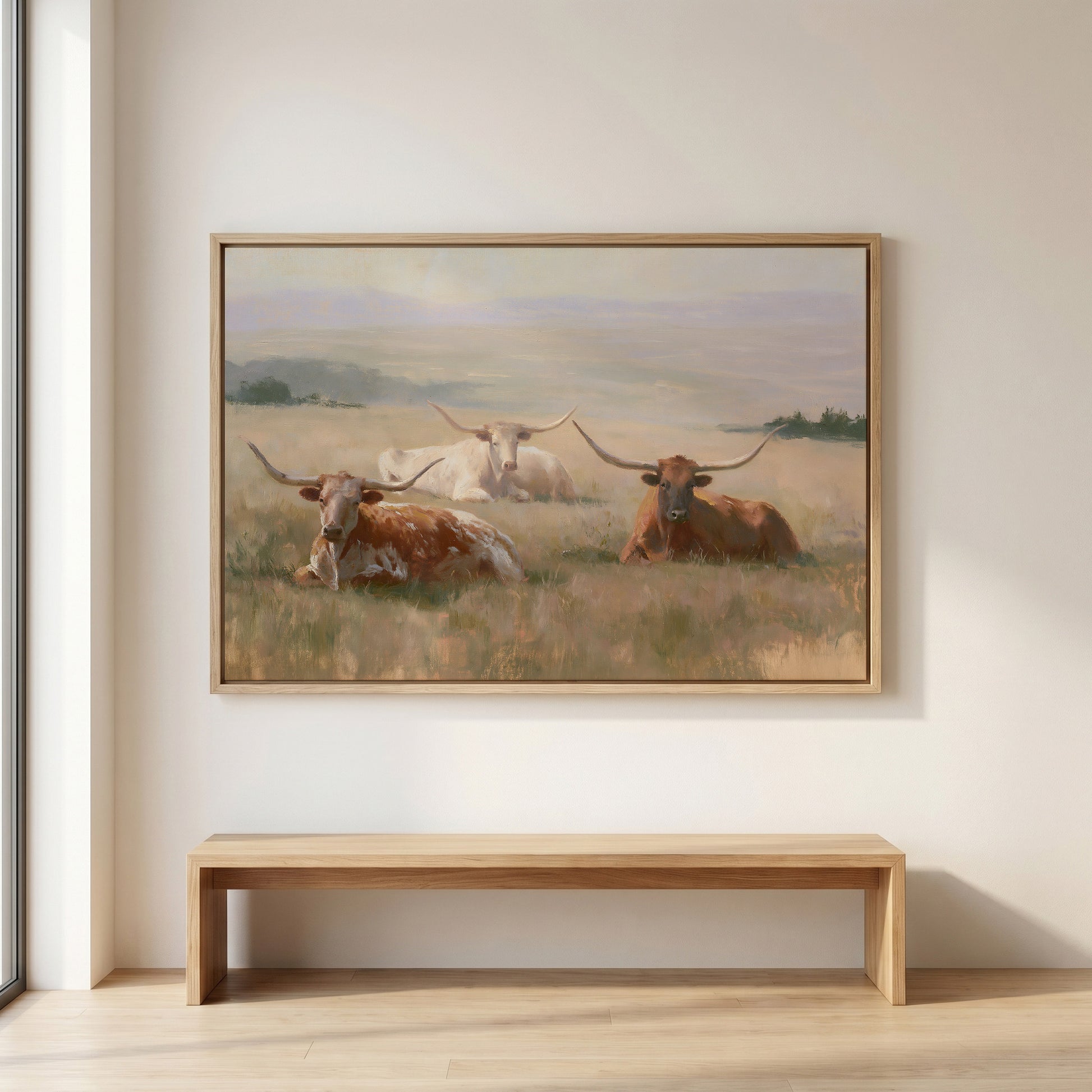 a large painting of three longhorns resting in a grassy field.
