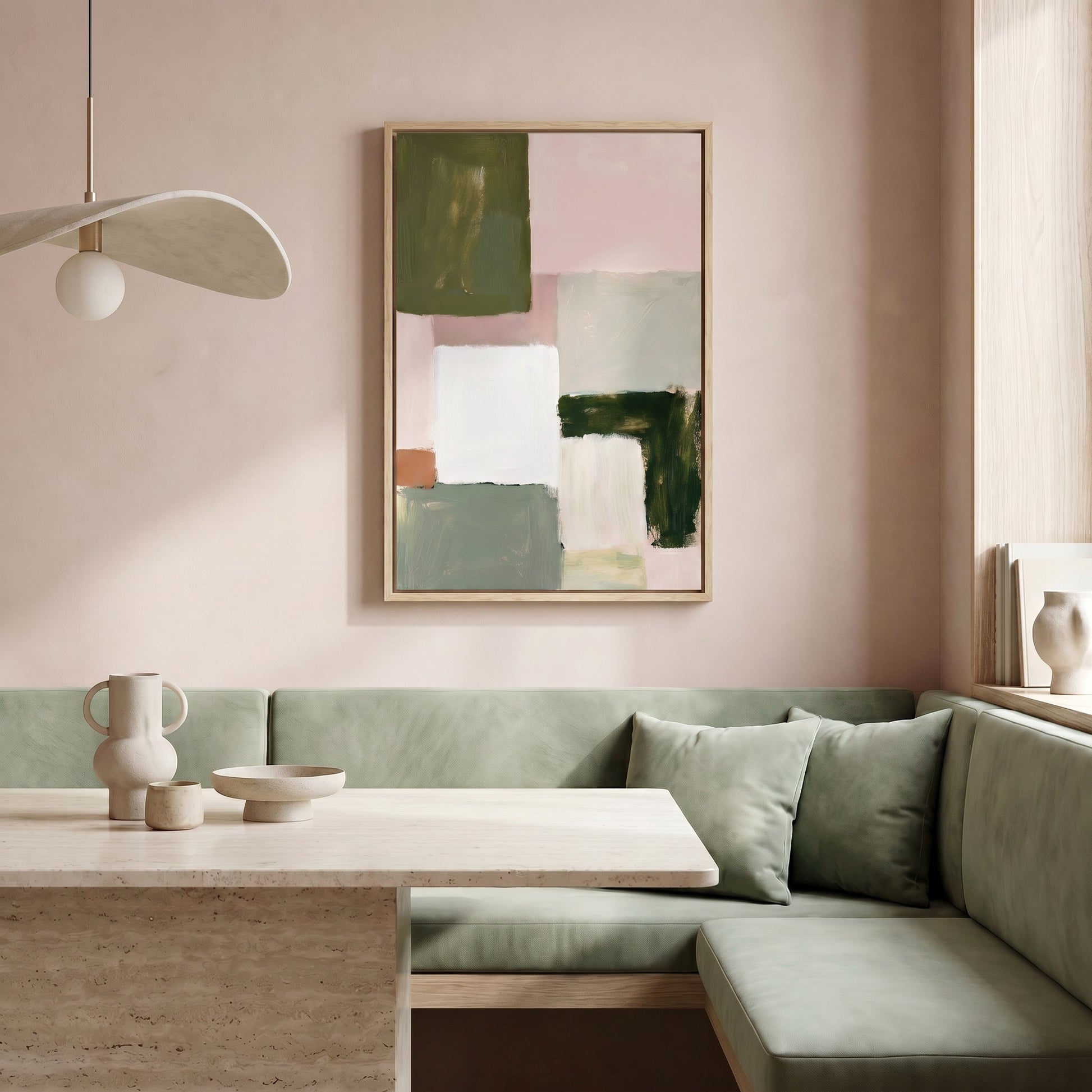 a modern and minimalist dining area with a light pink wall, a large abstract painting, a white table with a bowl and vase, and a green sofa.