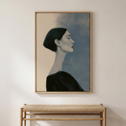a framed painting of a woman's profile, hanging on a wall above a wooden bench.