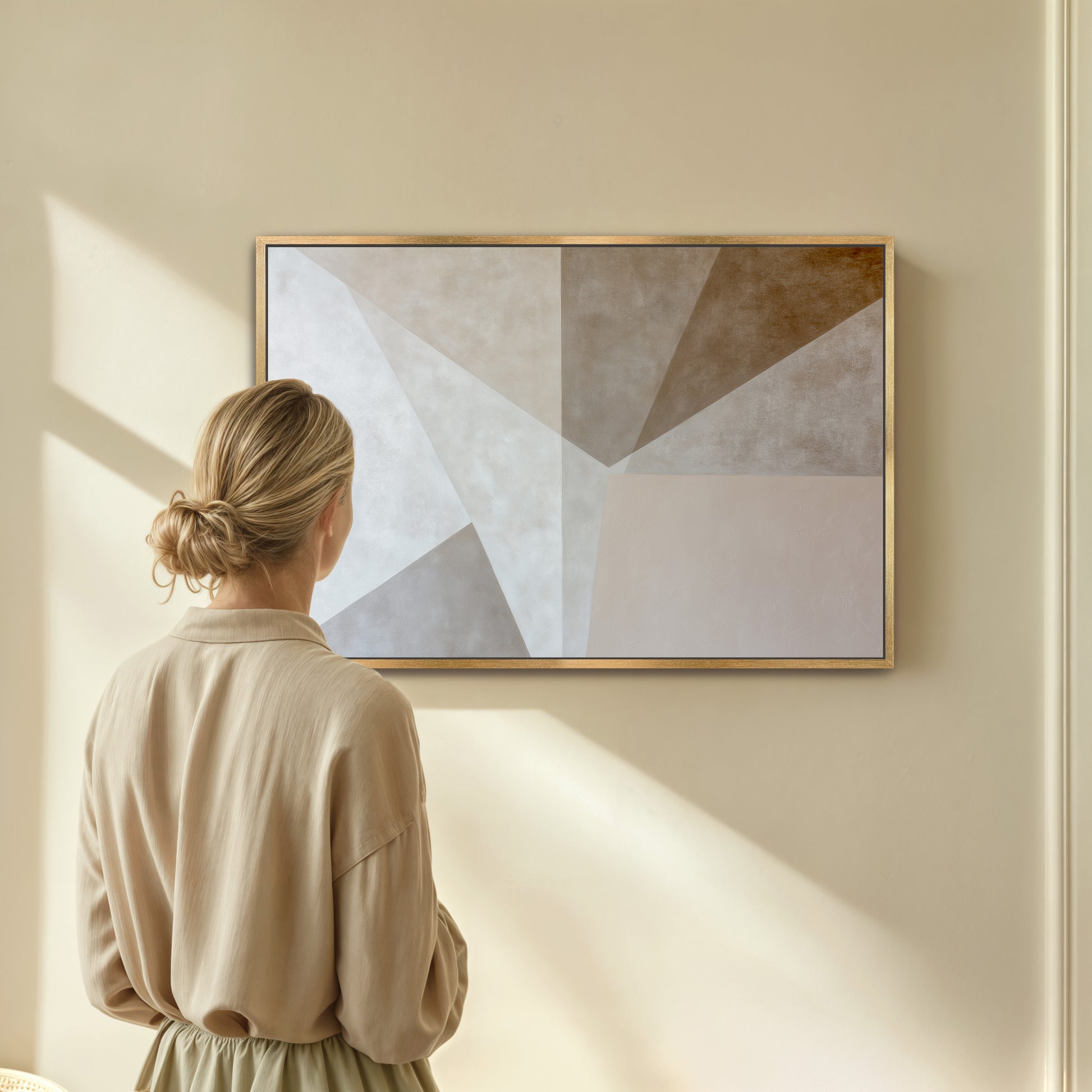 A woman in a beige dress stands in front of a large abstract painting on a wall, gazing at it.