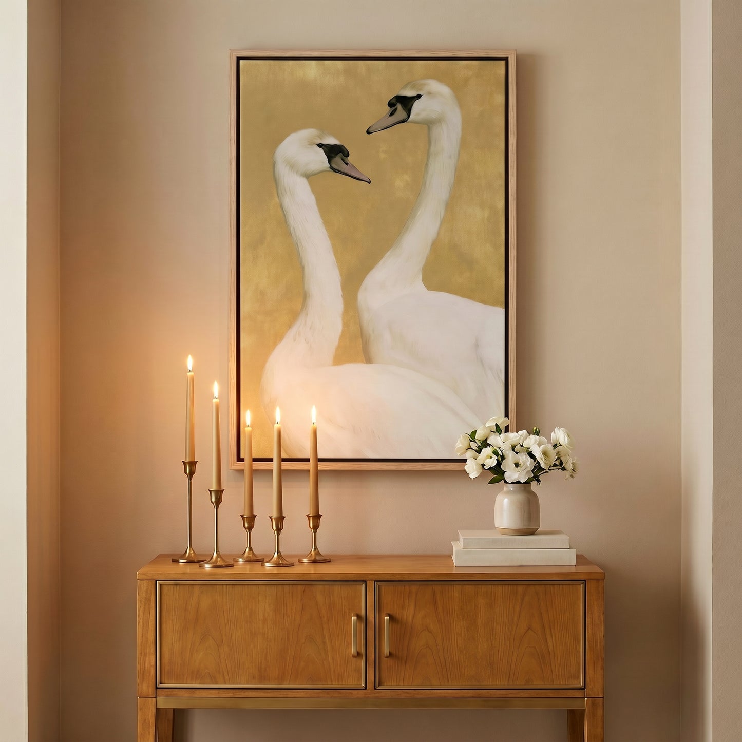 a wooden cabinet with a vase of flowers and a framed picture of two swans on the wall above it.