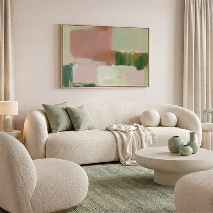 a modern living room with a large abstract painting on the wall, a white sofa with green throw pillows, a round coffee table with three green vases, and a beige armchair.