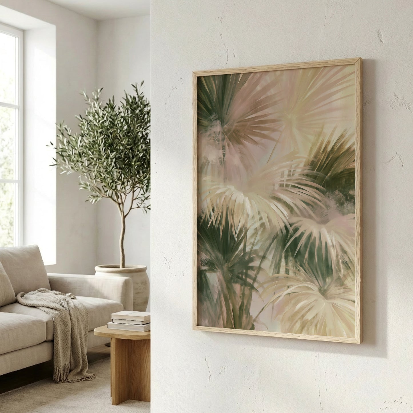 a living room with a large framed print of palm leaves hanging on the wall, a comfortable couch, and a potted plant in the background.