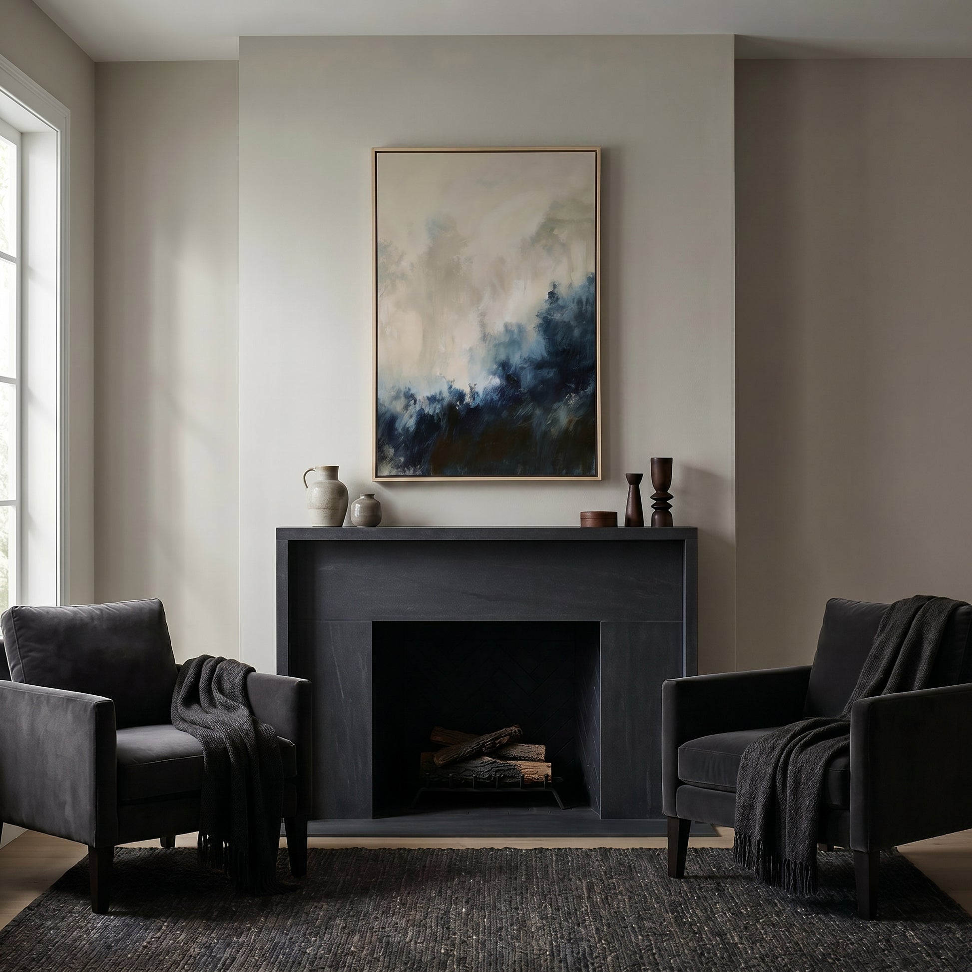 a cozy living room with a fireplace, two black armchairs, and a large abstract painting hanging above the fireplace.