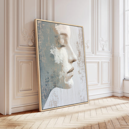 a large, framed painting of a woman's face leaning against a white wall.