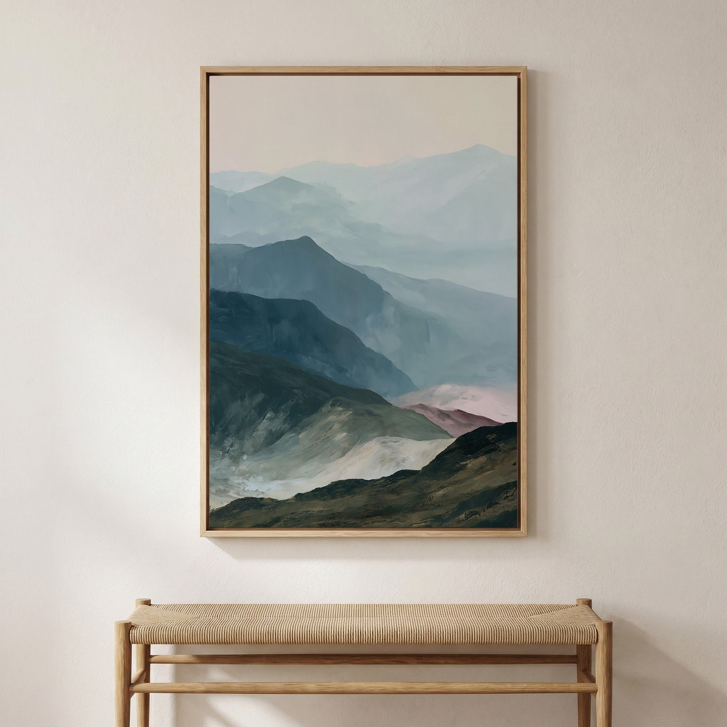 a large framed painting of a mountainous landscape hanging on a wall above a wooden bench.