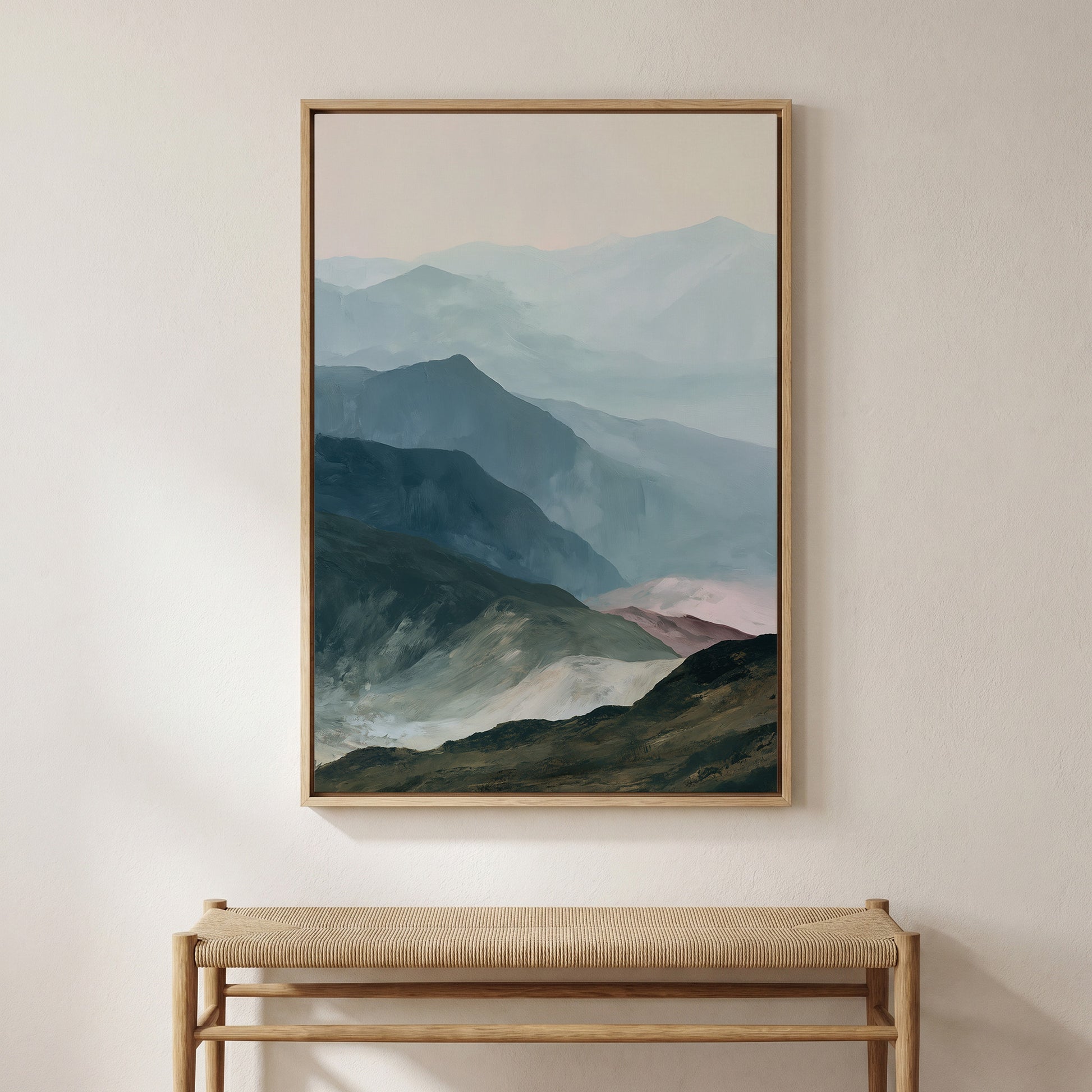 a large framed painting of a mountainous landscape hanging on a wall above a wooden bench.