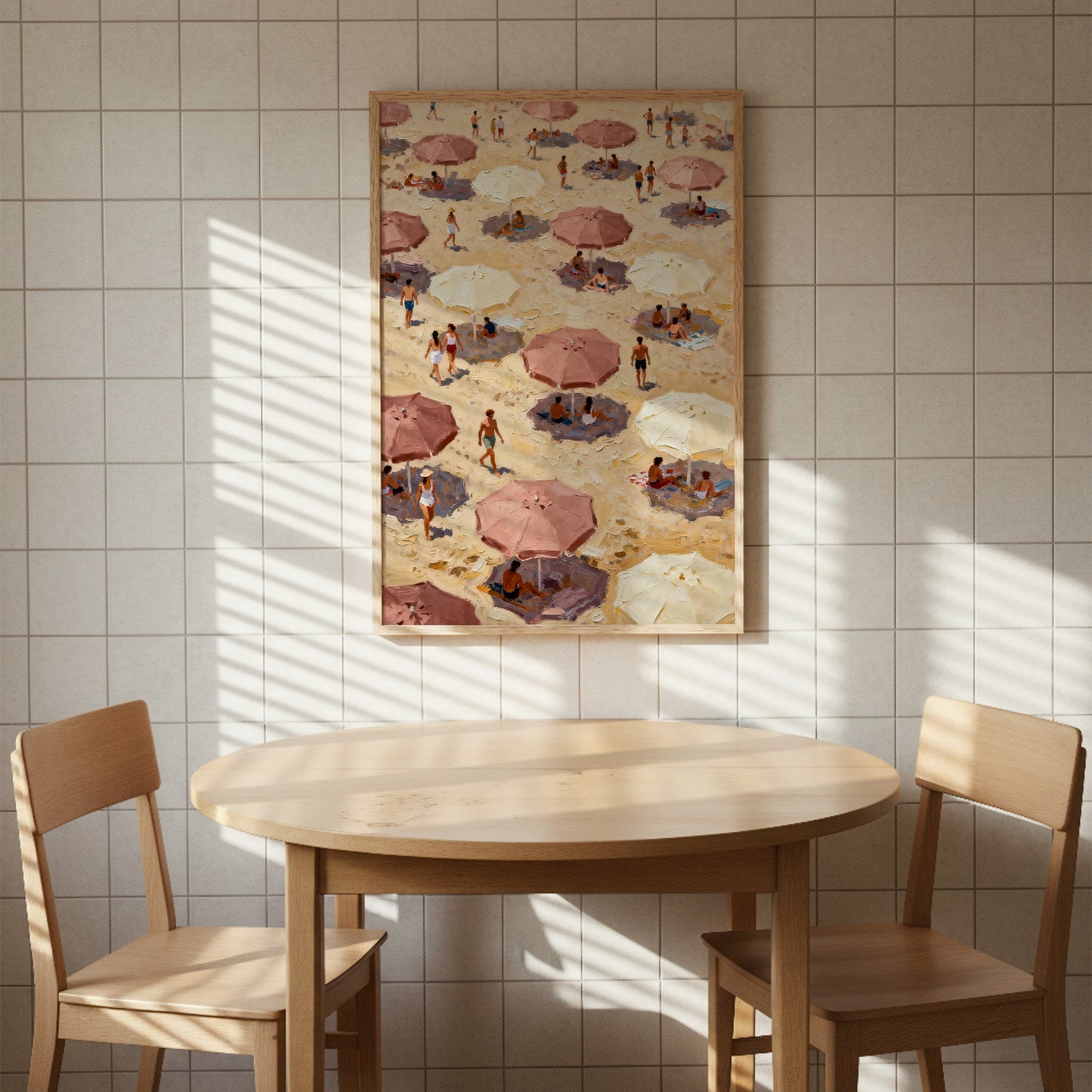 a beach scene with people under umbrellas, as depicted in a framed painting hanging on the wall above a wooden table with two chairs.