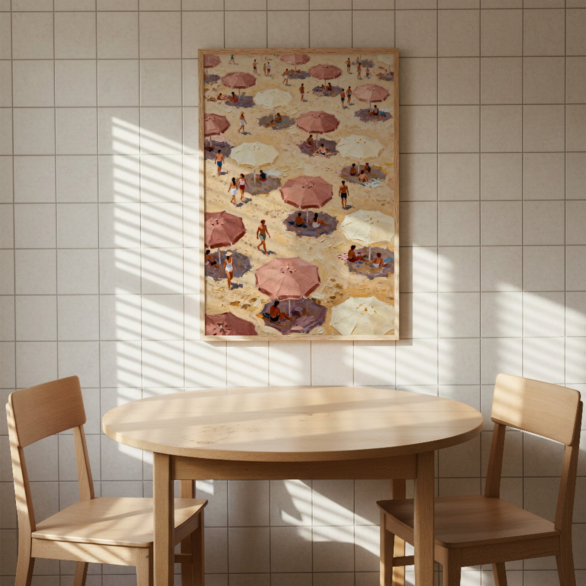 a beach scene with people under umbrellas, as depicted in a framed painting hanging on the wall above a wooden table with two chairs.
