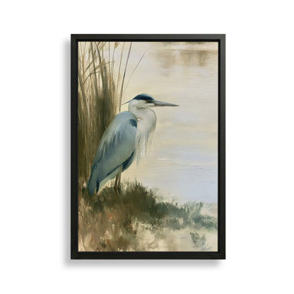 A framed painting depicting a blue heron standing on the bank of a body of water, surrounded by tall grasses.