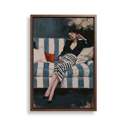 A woman in a black and white striped dress is sitting on a blue and white striped couch, with a red pillow on the couch.