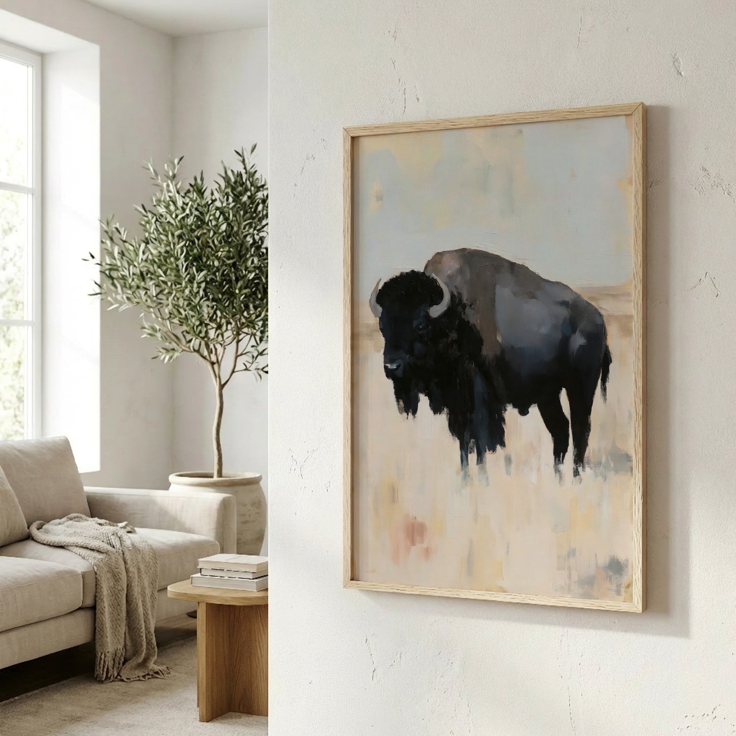 a large painting of a black bison in a field, hanging on a white wall in a living room.