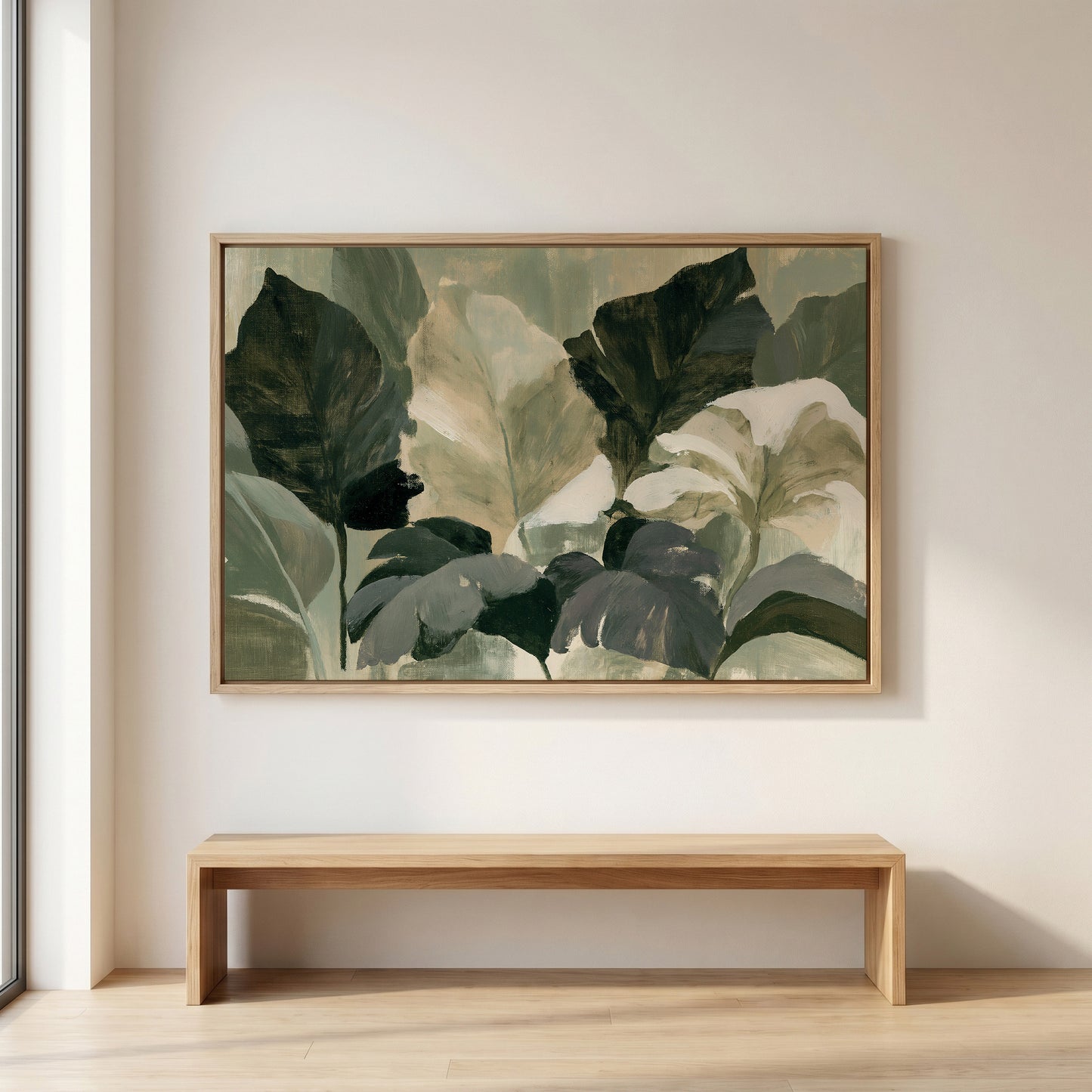 a large painting of green leaves hanging on a wall above a wooden bench.
