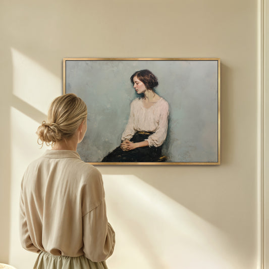 Woman standing in front of framed contemplative portrait, sunlight casting across a beige wall.