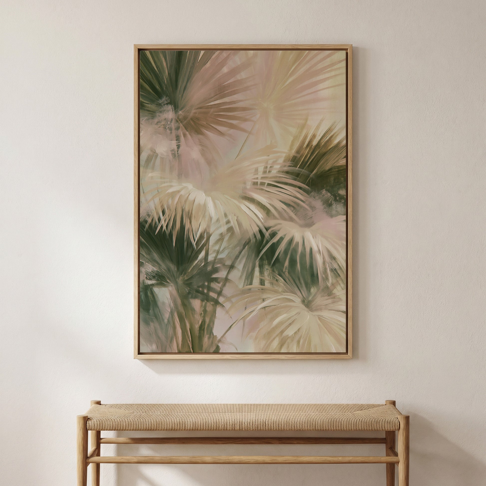 a large framed painting of palm leaves hanging on a wall above a wooden bench.