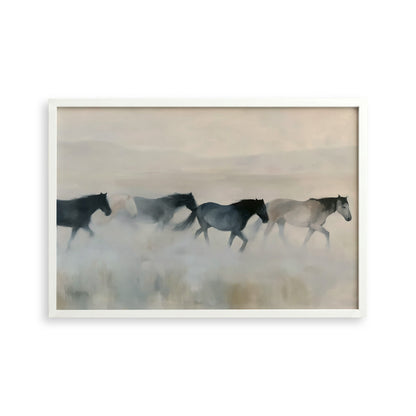 A group of horses running across a field, with a hazy, misty background.