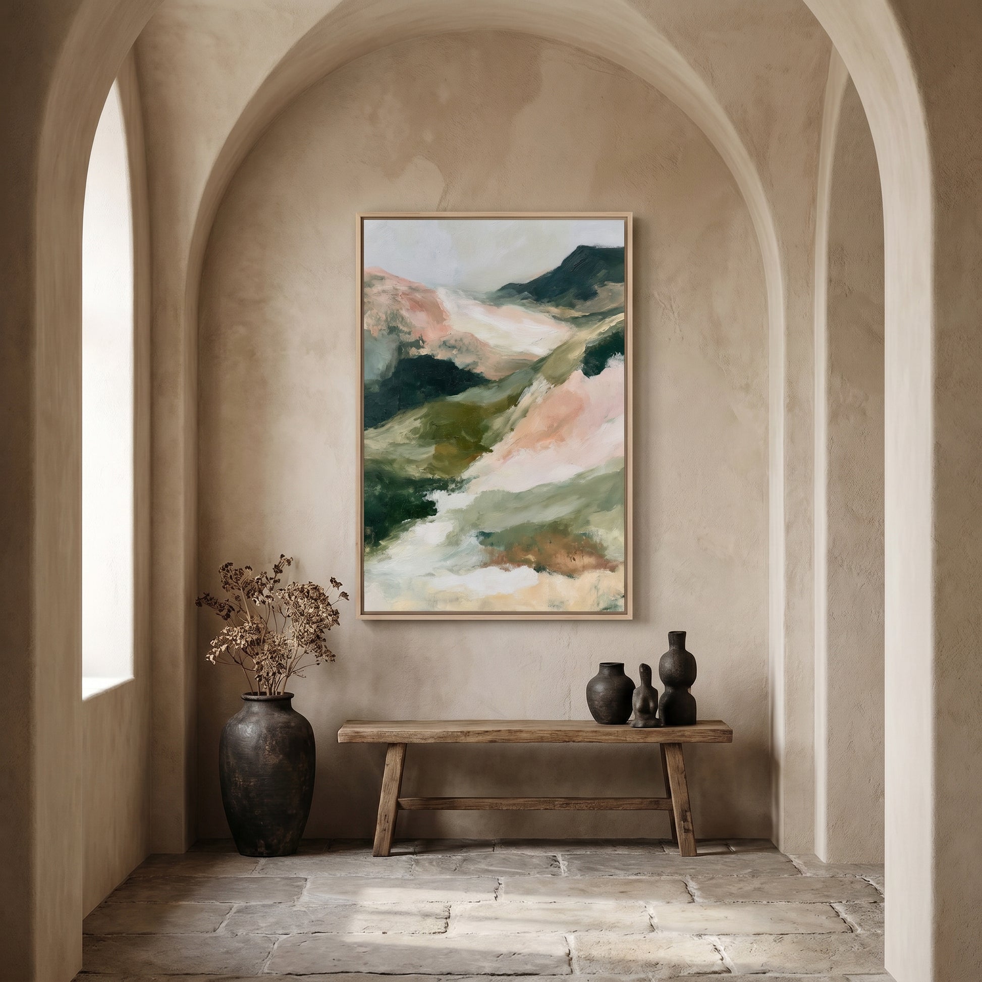 a large painting of a mountain landscape hanging on a wall, with a wooden bench and two vases placed in front of it. The room has arched doorways and a stone floor, creating a cozy and inviting atmosphere.