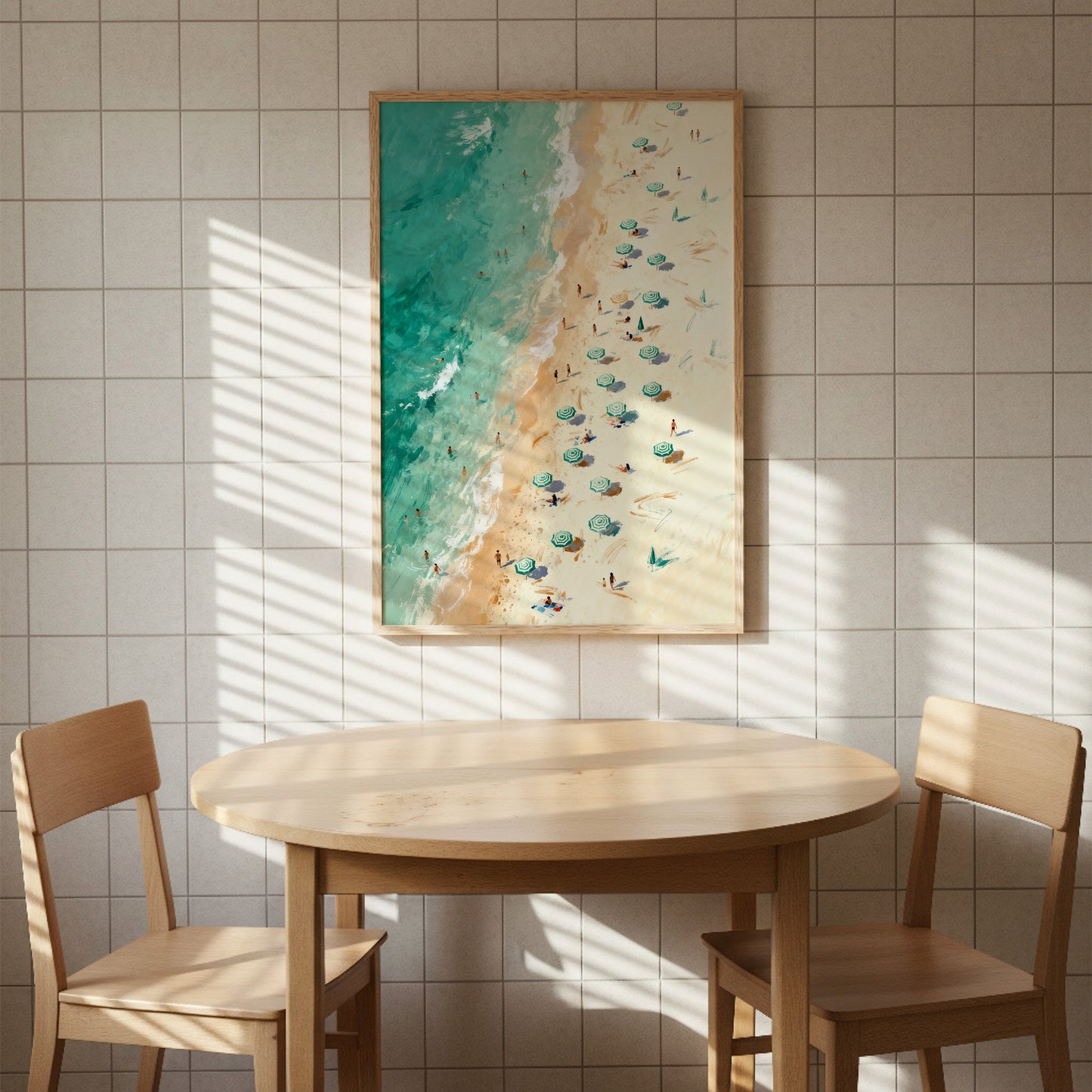 a beach scene with a painting of people walking on the beach and umbrellas, hanging on a tiled wall above a round wooden table with two chairs.