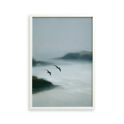 Two birds flying over a misty, foggy landscape.