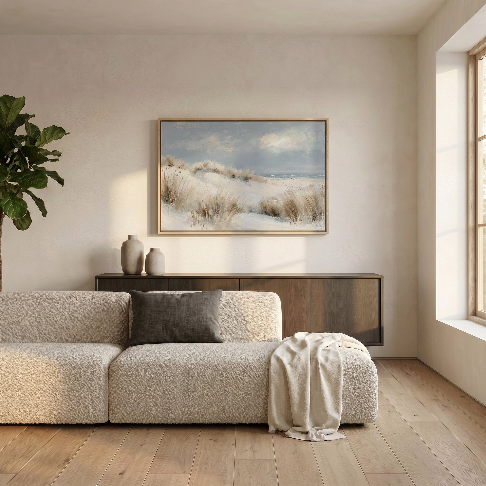 a serene living room with a large window, a beige sofa, a wooden cabinet, and a framed landscape painting on the wall.