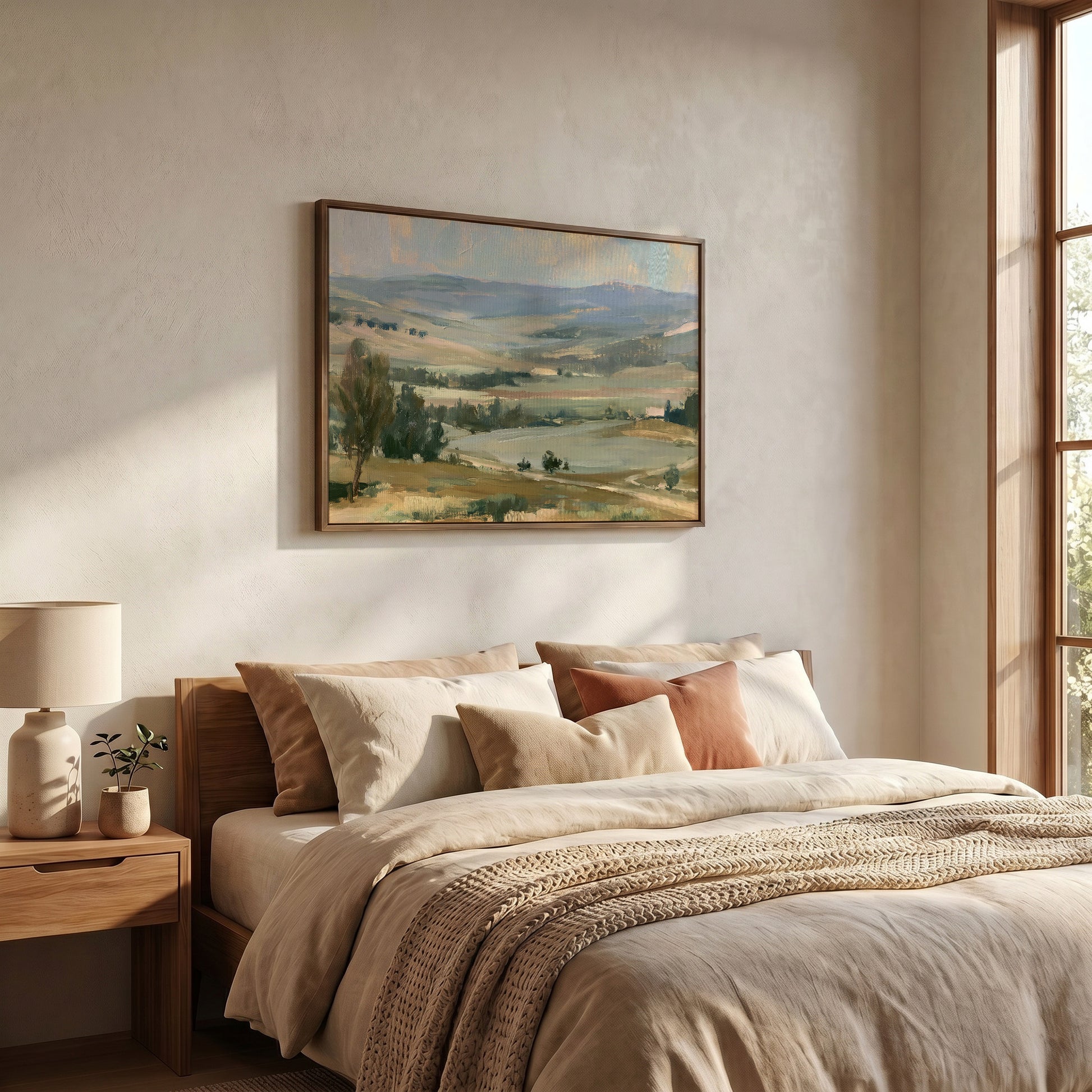 a serene bedroom scene with a large landscape painting hanging on the wall above a bed with a beige comforter and pillows.