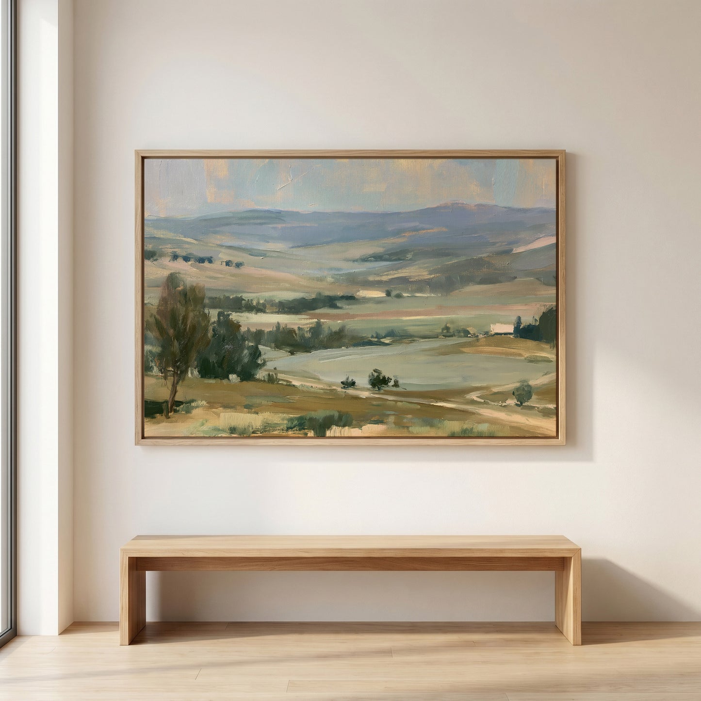 a large landscape painting hanging on a white wall above a wooden bench.