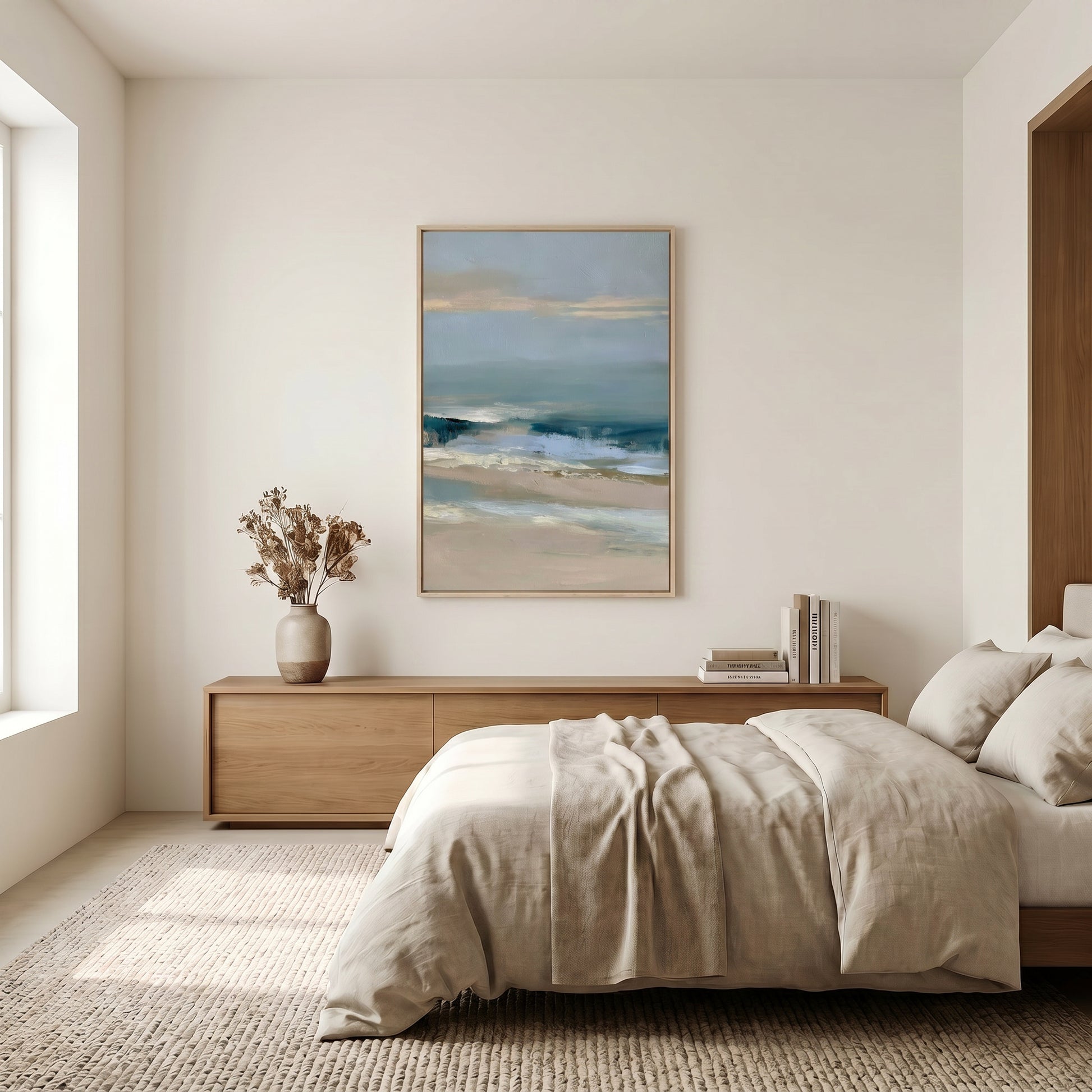 a serene bedroom with a large bed, a wooden dresser, and a framed painting of a beach scene hanging on the wall.