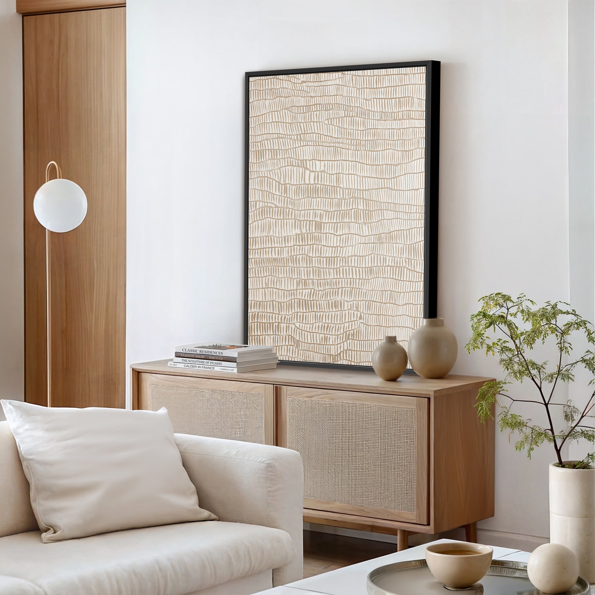 a modern living room with a white sofa, a wooden cabinet, a large abstract painting on the wall, and a potted plant.