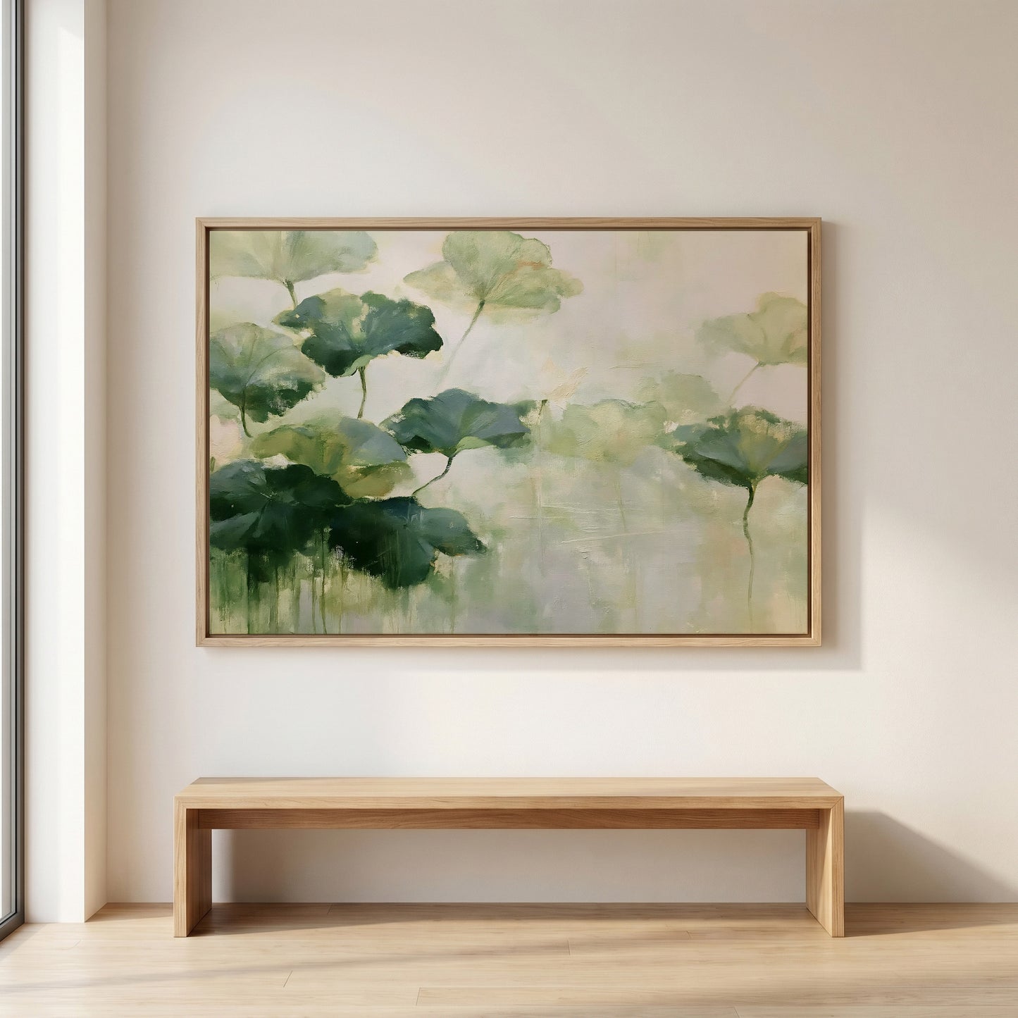 a large painting of green leaves hanging on a wall above a wooden bench.