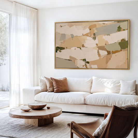 a modern living room with a large abstract painting on the wall above a white sofa. The room has a wooden coffee table and a leather armchair, creating a cozy and inviting atmosphere.