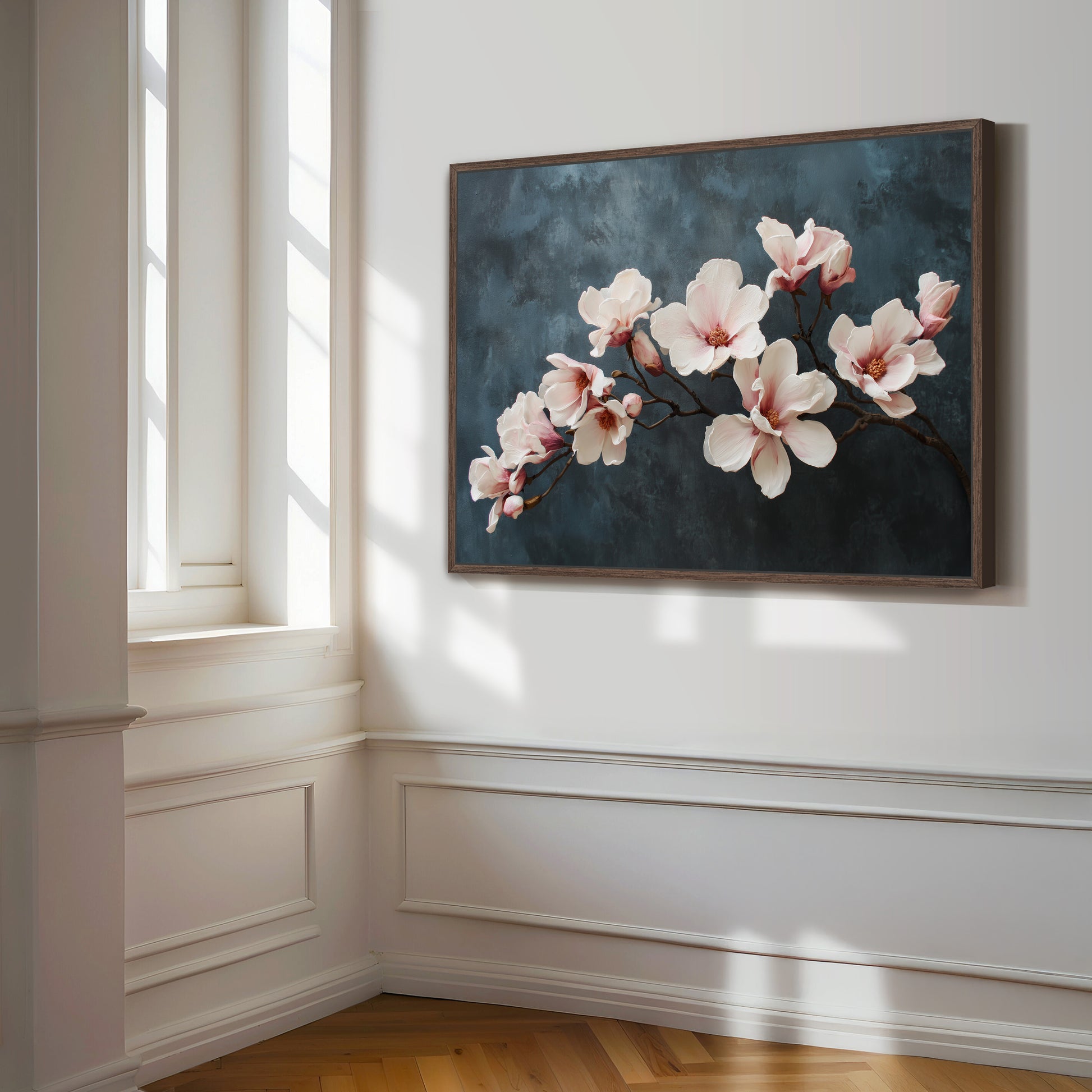 Framed artwork of pink flowers on a wall in a room with sunlight streaming through a window.