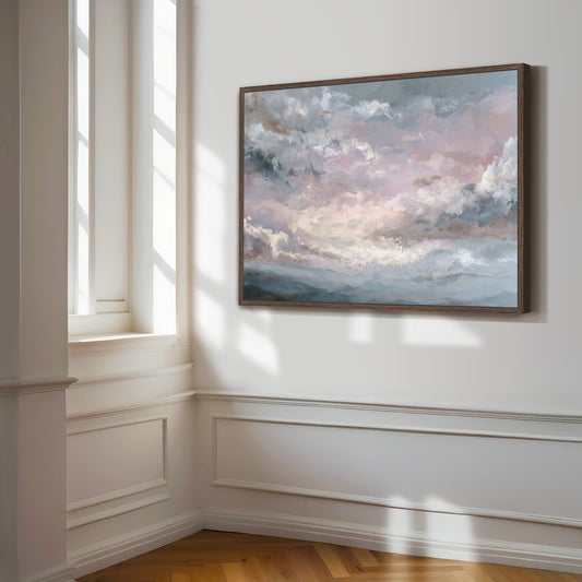 Man hanging pastel pink sky artwork on wall, unframed print.