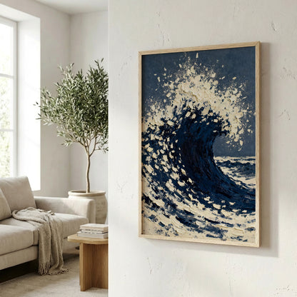 a large framed painting of a crashing wave, hanging on a wall in a living room. The painting is predominantly blue and white, with splashes of white creating a sense of movement and energy. In the background, there is a window with a tree outside, adding a natural element to the scene. The room also contains a couch, a coffee table, and some books, creating a cozy and inviting atmosphere.
