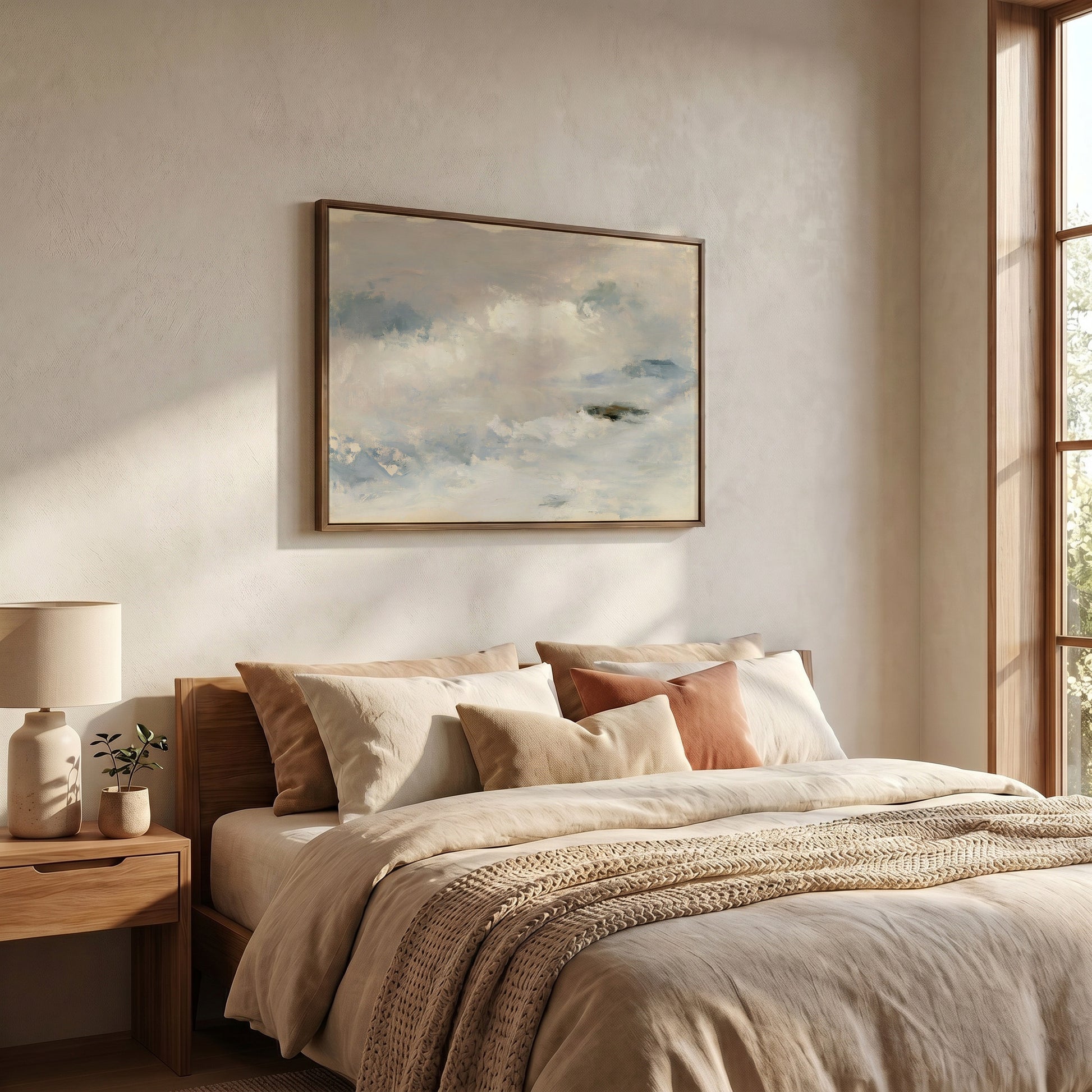 a serene and cozy bedroom with a large bed adorned with beige bedding and a wooden headboard. Above the bed, a framed painting of a cloudy sky adds a touch of nature to the room. The room is well-lit, with natural light streaming in from a window on the right side, creating a warm and inviting atmosphere.