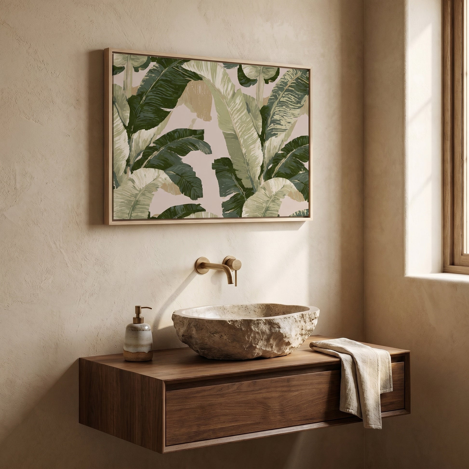 a bathroom sink with a stone basin, a wooden cabinet below it, and a framed print of green leaves hanging above the sink.