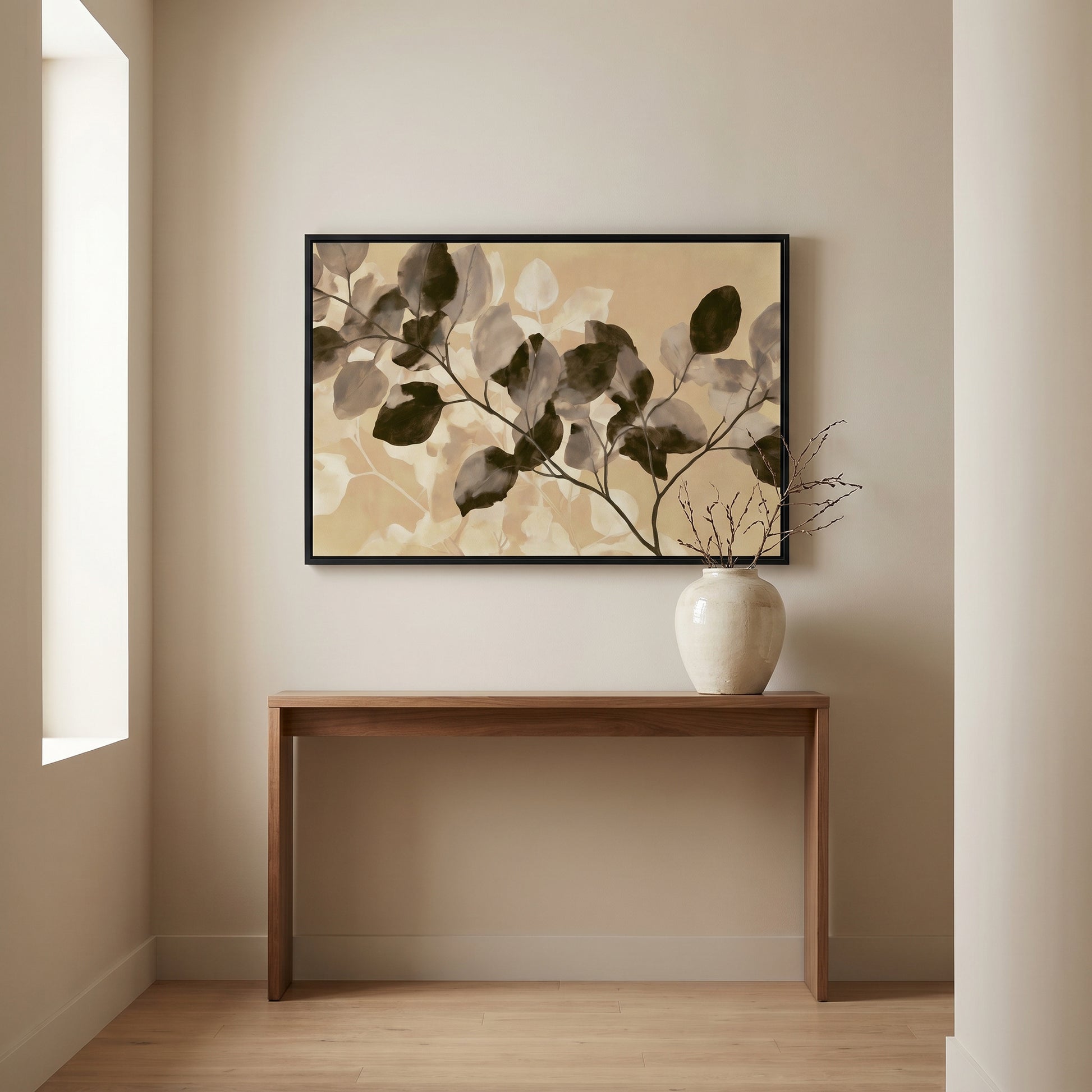 a wooden console table with a white vase on top, set against a wall with a framed painting of leaves hanging above it.