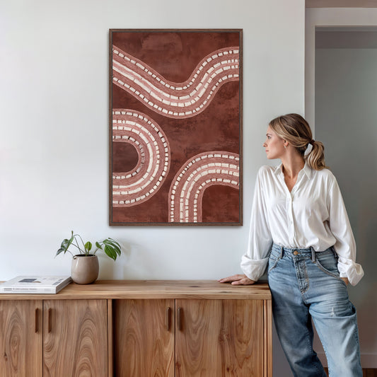 Woman standing next to a wooden cabinet with a large abstract painting on the wall.