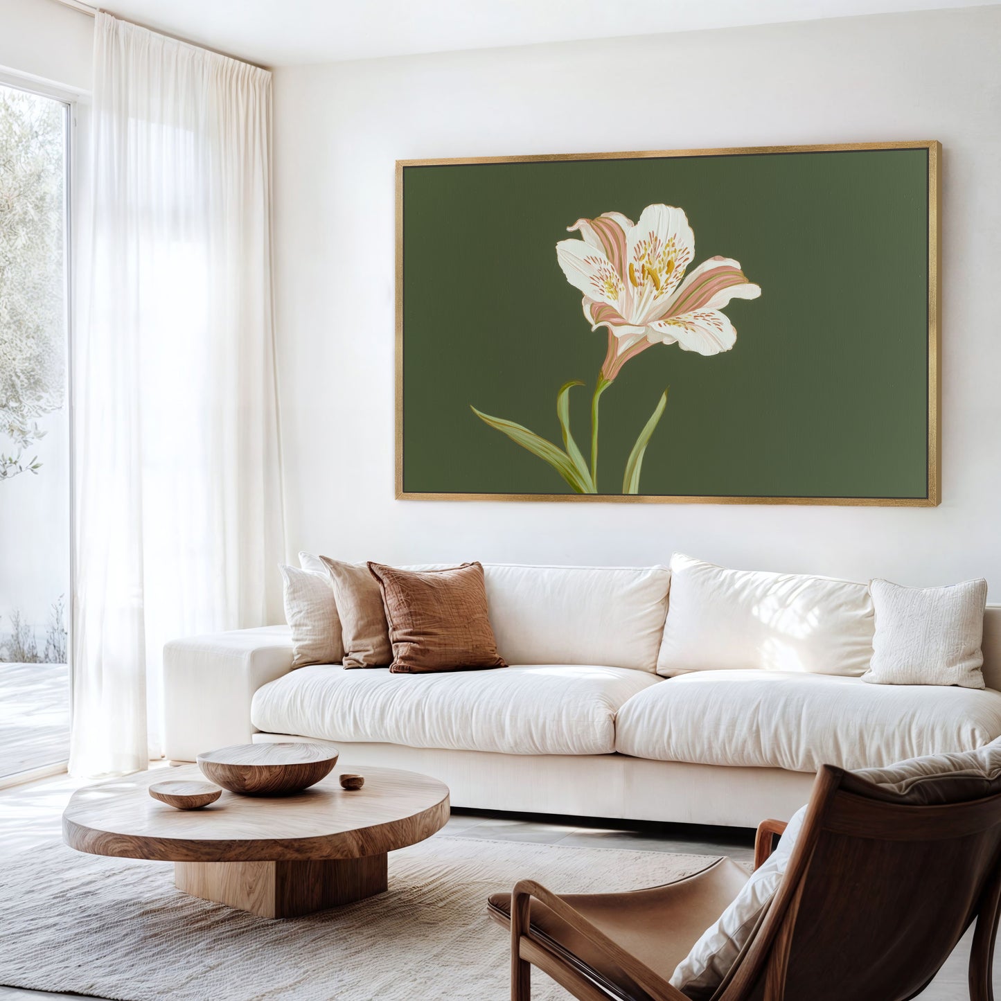 Large white lily floral canvas in gold frame displayed above neutral sofa in bright living room