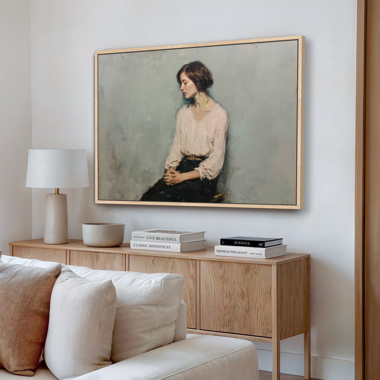 Serene seated woman portrait painting with oak wood frame on light wall.