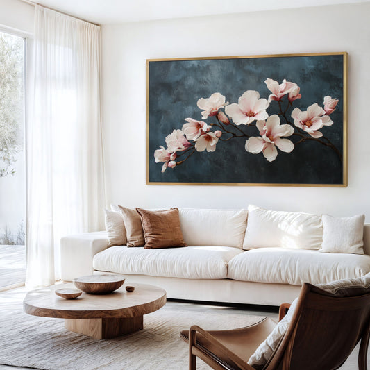 Magnolia floral canvas wall art in natural frame styled above a sofa.