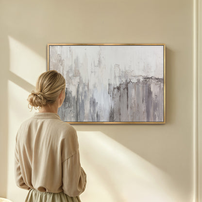 Woman viewing neutral abstract wall art on beige wall