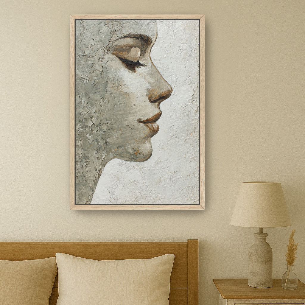 Oak-framed feminine portrait wall art hanging above neutral bed in minimalist bedroom setting.